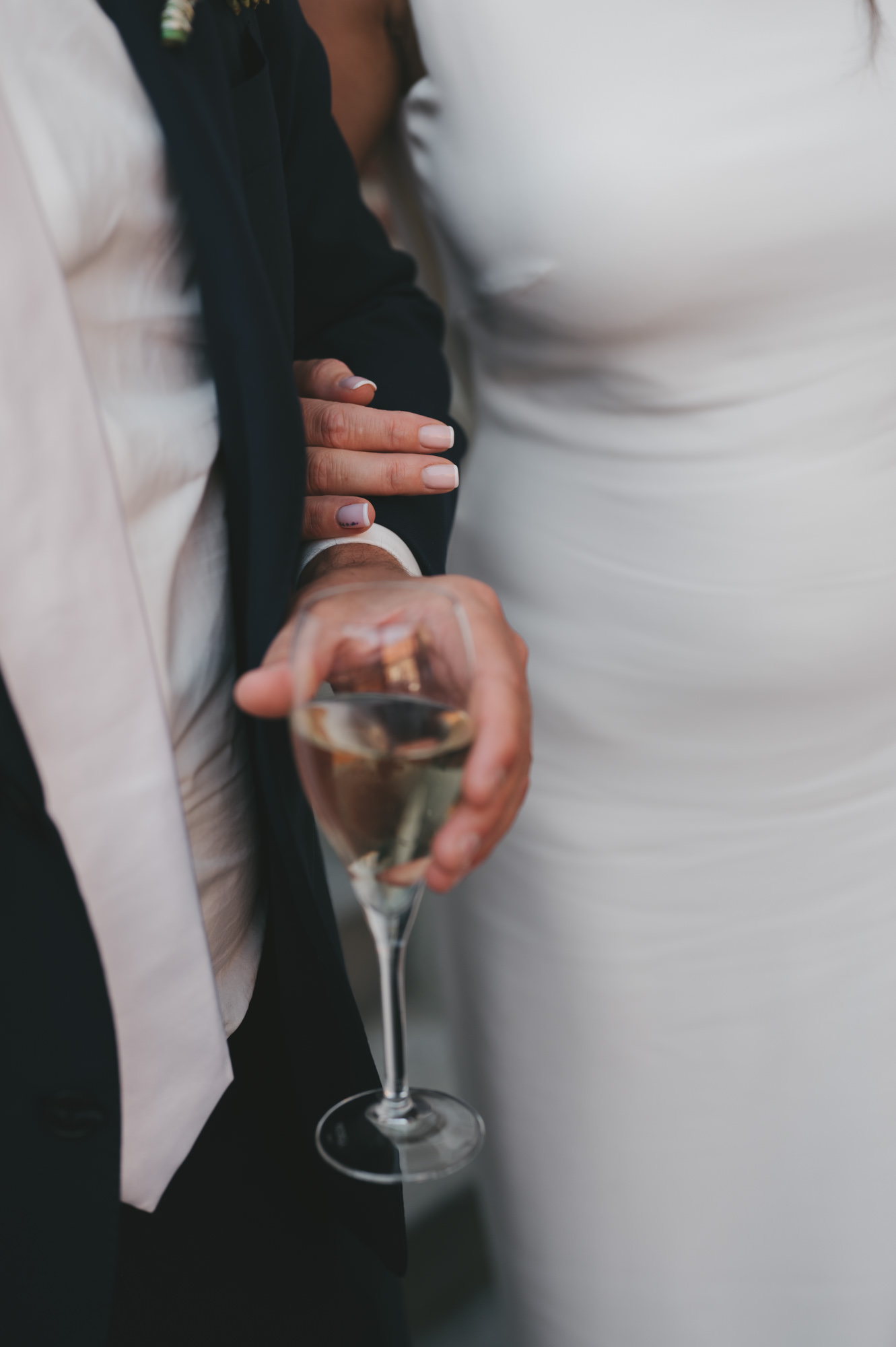 Detailfoto van een bruid en bruidegom met een glas champagne. Elegante en stijlvolle trouwfotografie door TwentyTwelve Photography