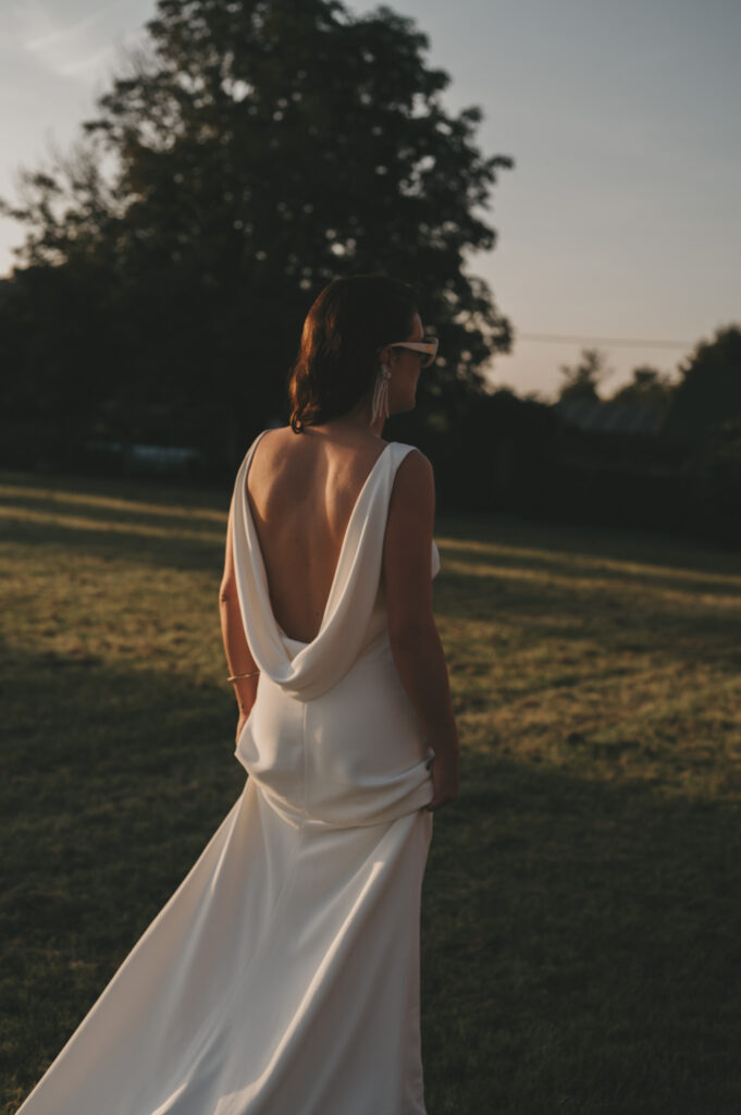 Stijlvolle bruid in een elegante trouwjurk met open rug tijdens golden hour, vastgelegd door trouwfotograaf TwentyTwelve Photography