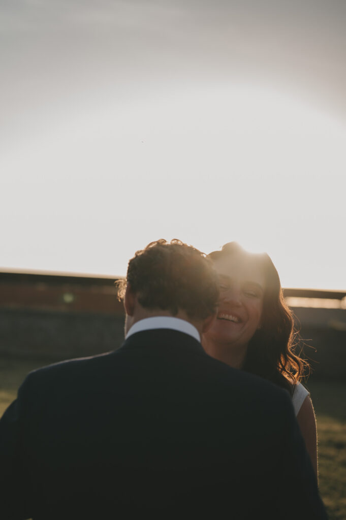 Filmische en tijdloze trouwfotografie tijdens golden hour. Het bruidspaar danst en geniet van een romantisch en spontaan moment in het warme avondlicht.