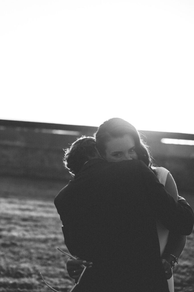 Filmische en tijdloze trouwfotografie in zwart wit tijdens golden hour. Het bruidspaar danst en geniet van een romantisch moment in het warme avondlicht