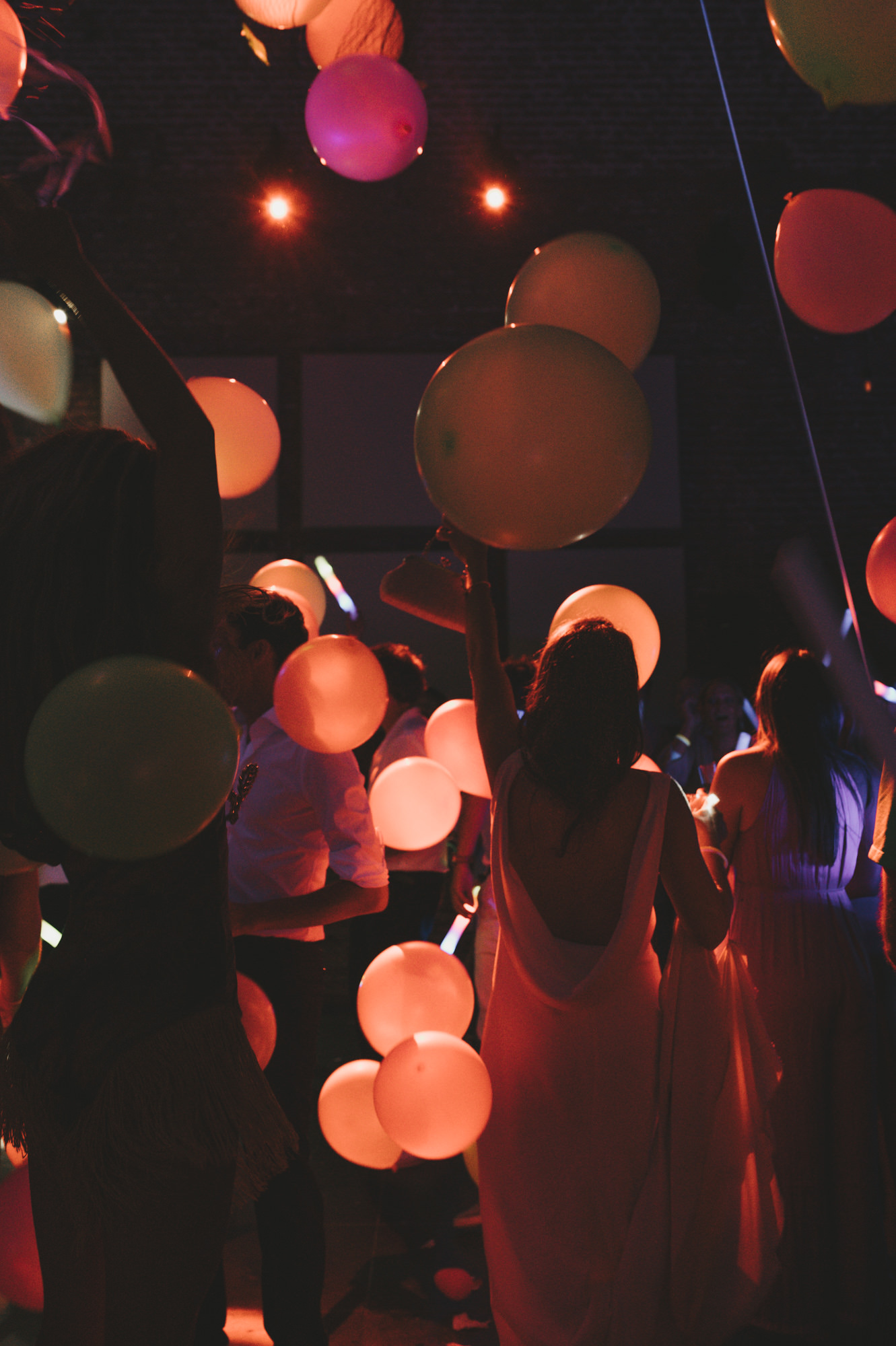 Bruid loopt door ballonnen en lichtshow tijdens trouwfeest