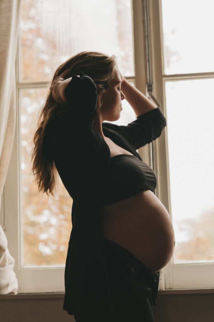 Artistieke zwangerschapsfotografie - zwangere vrouw in eigen woonkamer in Bloemendaal