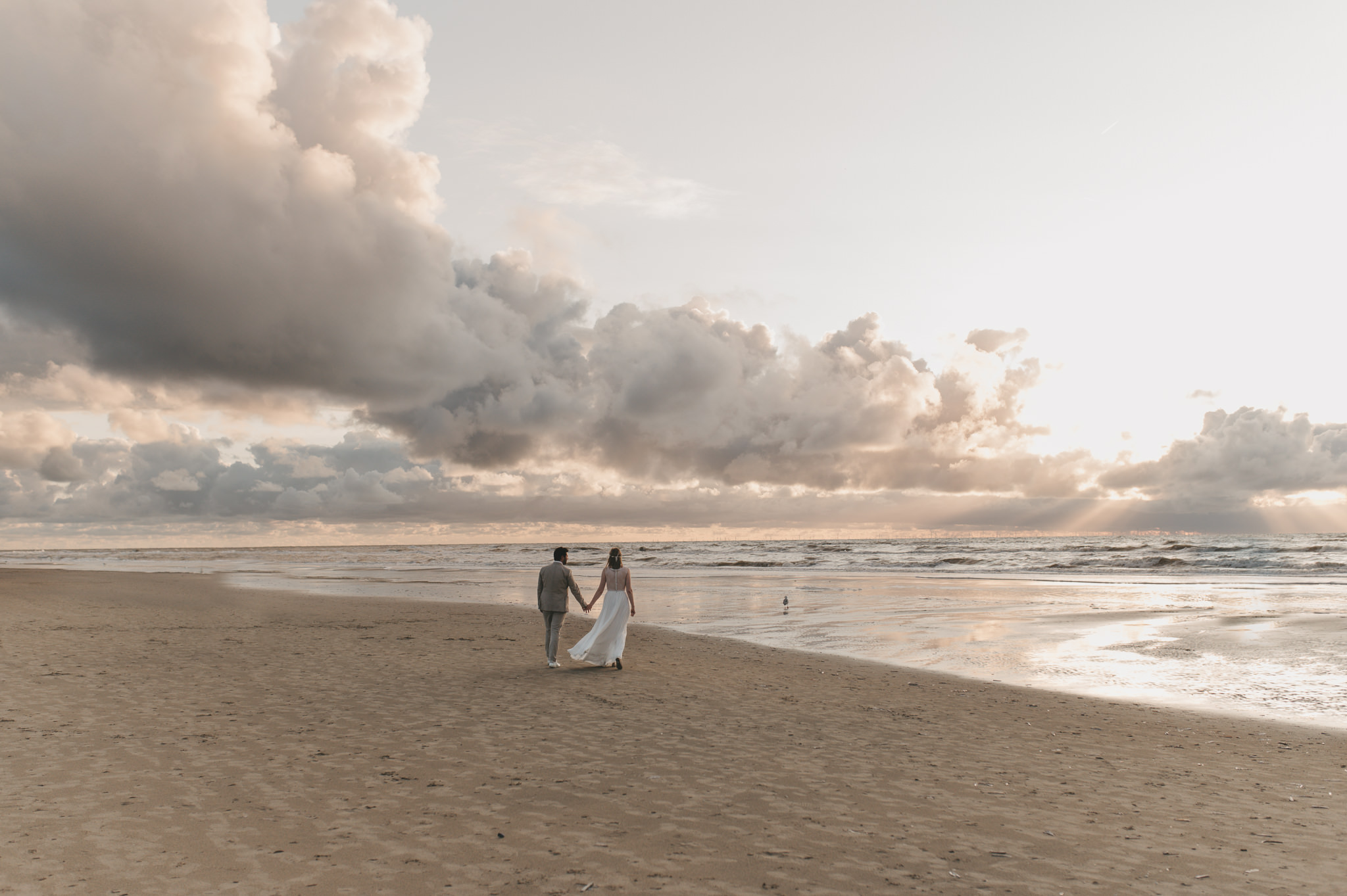 Bruidspaar loopt samen over het strand tijdens een strandbruiloft